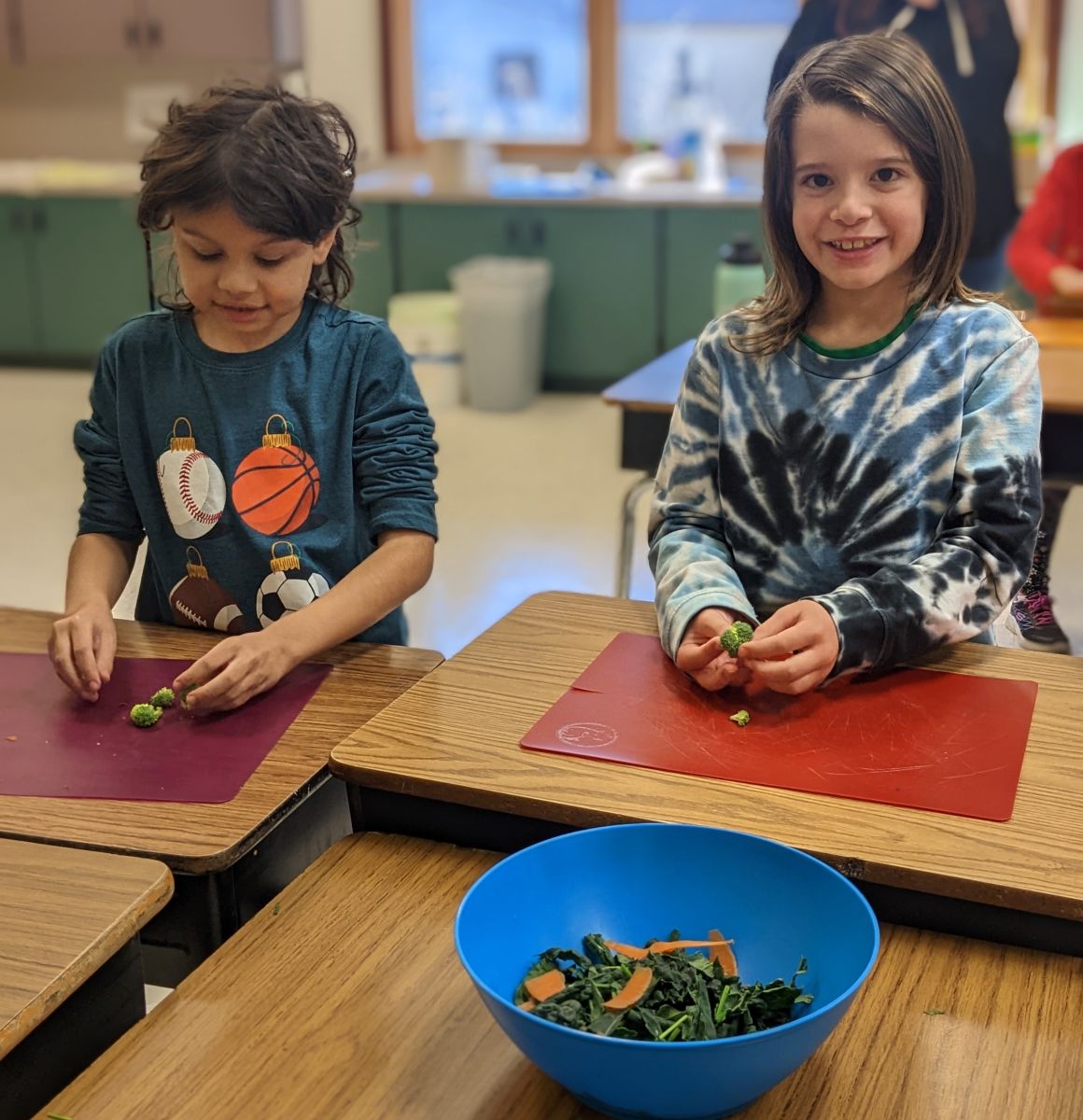 Two students help make salads during cooking classes.